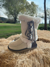 Load image into Gallery viewer, A pair of beige side lace premium sheepskin Ugg boots with soft wool cuff and leather tassel.